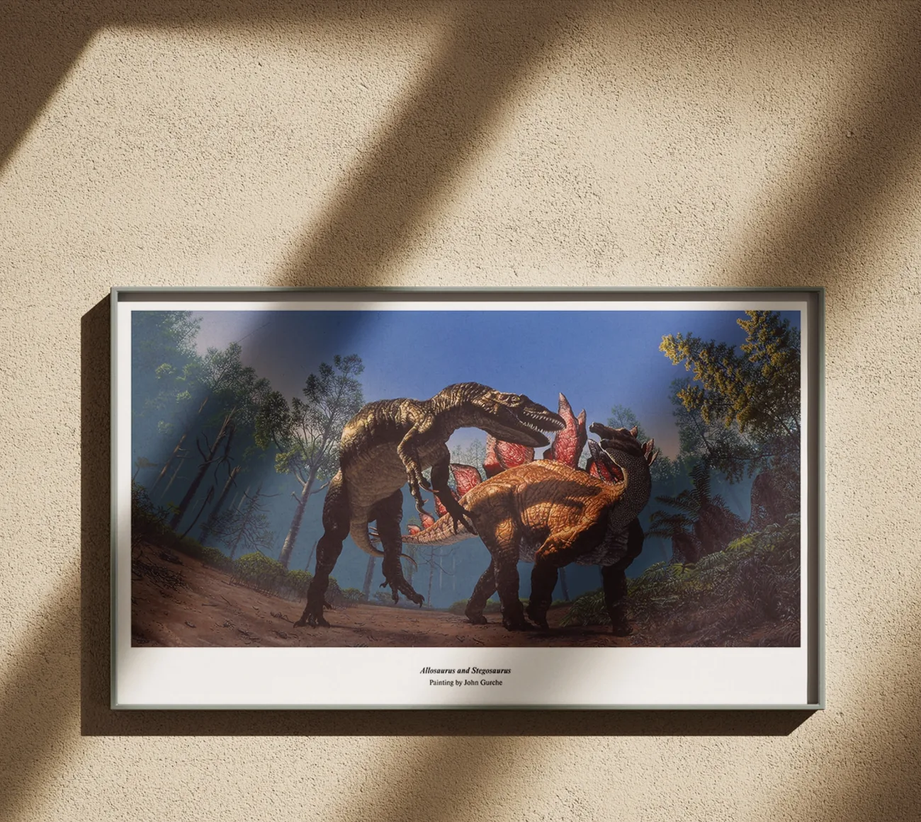 The Allosaurus and Stegosaurus panorama, framed in black on a warm plaster wall crossed by window light.