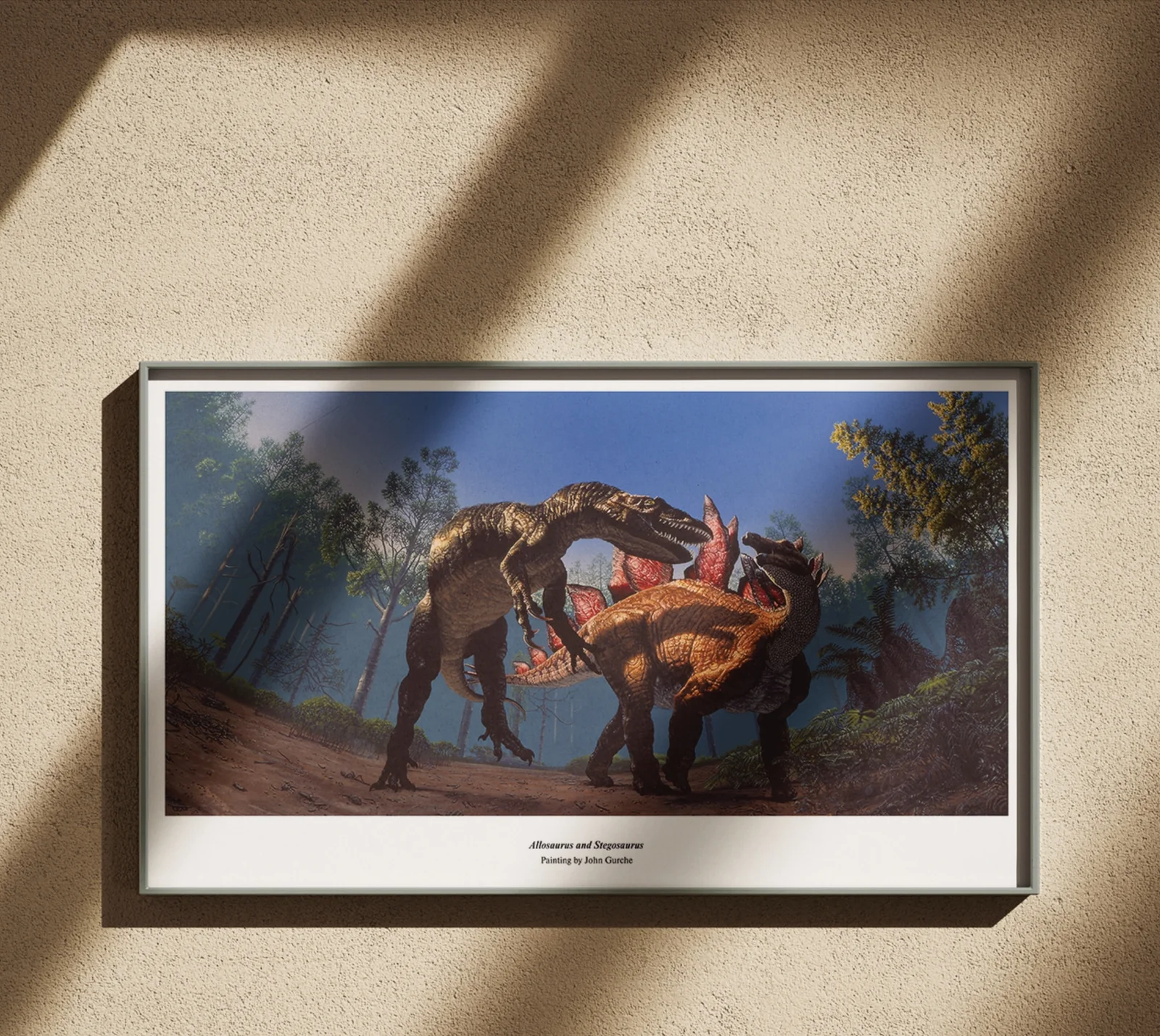 The Allosaurus and Stegosaurus panorama, framed in black on a warm plaster wall crossed by window light.