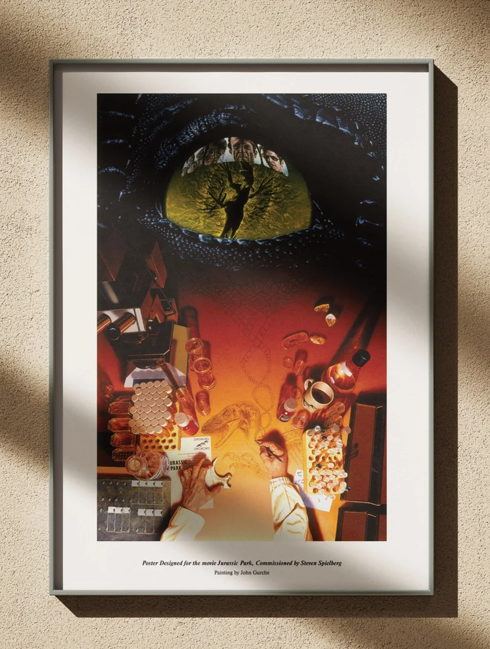The Jurassic Park poster painting, framed in black, hanging on a warm plaster wall above a dark sofa in late-afternoon light.