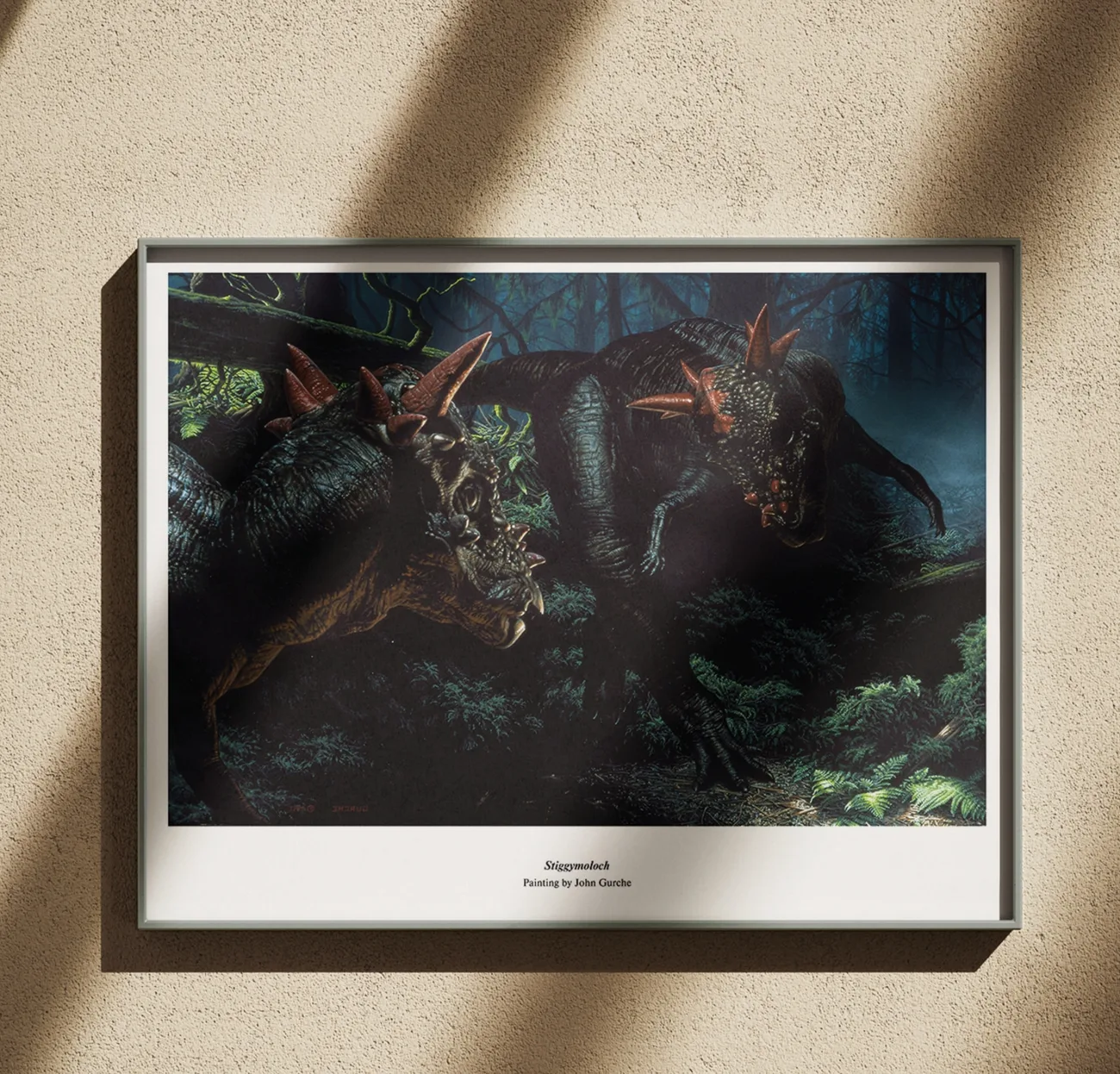 The Stygimoloch painting, framed in black on a warm plaster wall in raking afternoon light.
